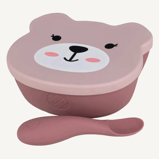 A pink silicone suction bowl with fitted lid and matching spoon, shaped for easy scooping and steady feeding during self-feeding stages.