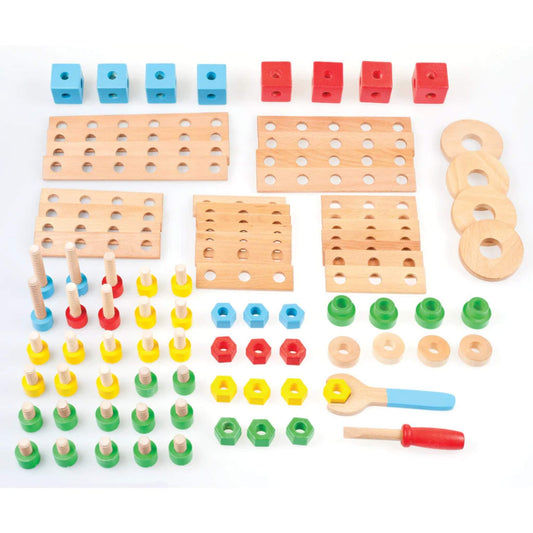 All 91 wooden pieces from the construction set laid out flat, including panels, bolts, blocks, wheels, nuts, and two toy tools in red and blue.
