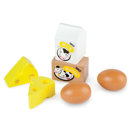 Toy milk and butter cartons, cheese wedges and eggs from a wooden dairy play set arranged outside of crate on a white background.