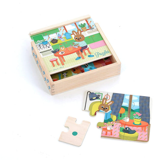 A wooden puzzle set stored in an open wooden box with the top puzzle showing a rabbit eating breakfast in a kitchen scene, alongside a partly completed living room puzzle.