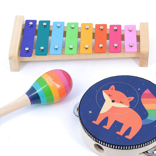 A rainbow-coloured xylophone with a wooden frame, a striped maraca, and a tambourine decorated with a fox illustration.