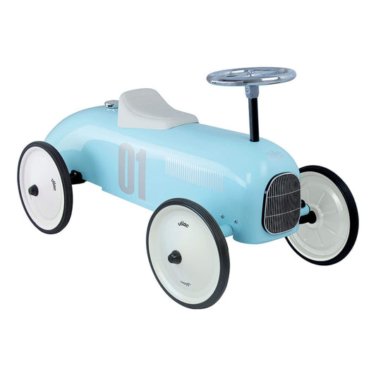 Side angled view of a light blue metal ride-on toy car with white seat, chrome steering wheel and number 01 decal on the side.