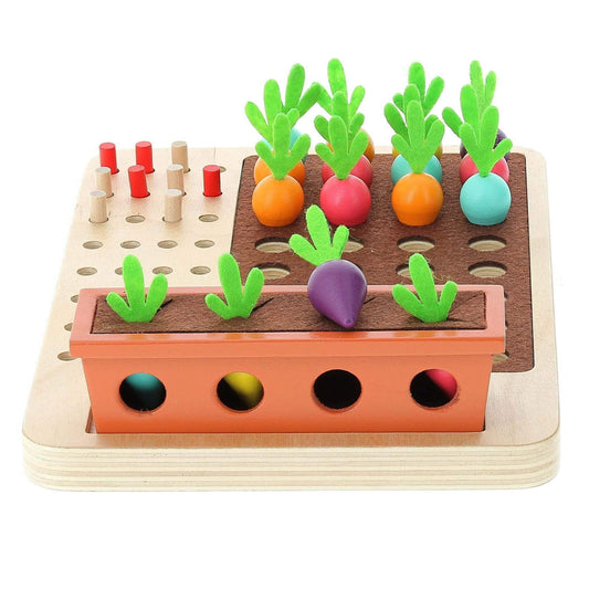 Wooden vegetable deduction game with colourful carrots and radishes planted in holes alongside a planter box.