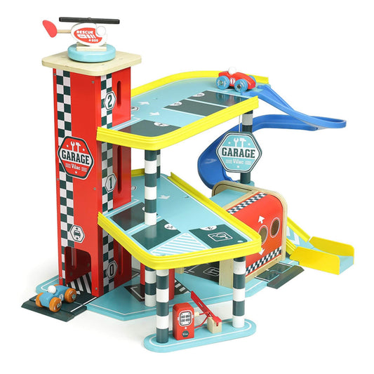Toy wooden garage featuring multi-level car track, helicopter landing pad, racing cars and blue slides for imaginative vehicle play.