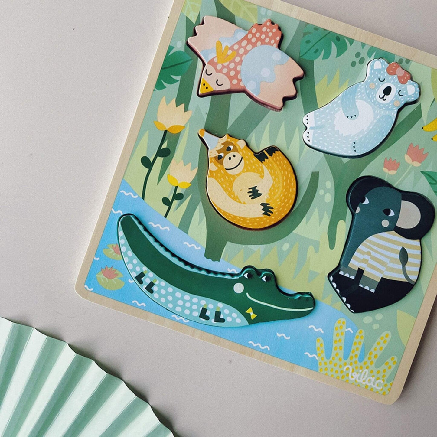 Close-up of a Touch and Feel Puzzle showing colourful wooden animal pieces fitted into their textured slots on a jungle-themed board.