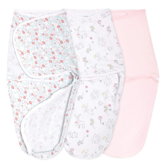 aden + anais swaddle wraps in floral, woodland animal, and blush pink prints, opened flat to show inner shape.
