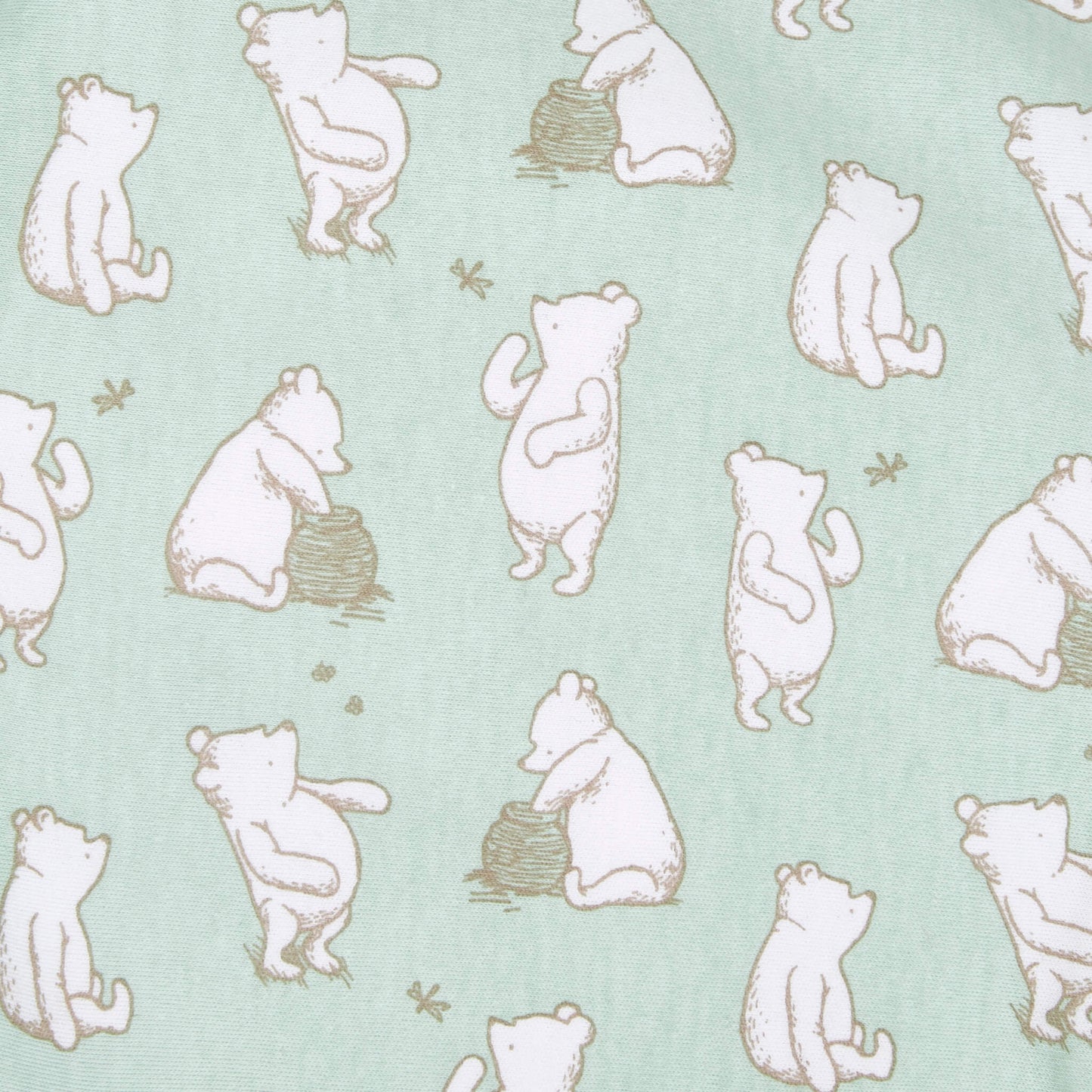 A close-up of green swaddle fabric with repeated illustrations of Winnie the Pooh in beige outline, showing various seated and standing poses with honey pots and bees.