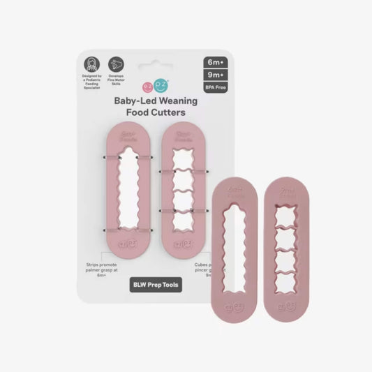 Blush pink Baby-led weaning food cutters displayed in retail packaging showing strip cutter and cube cutter designed for preparing baby finger foods.