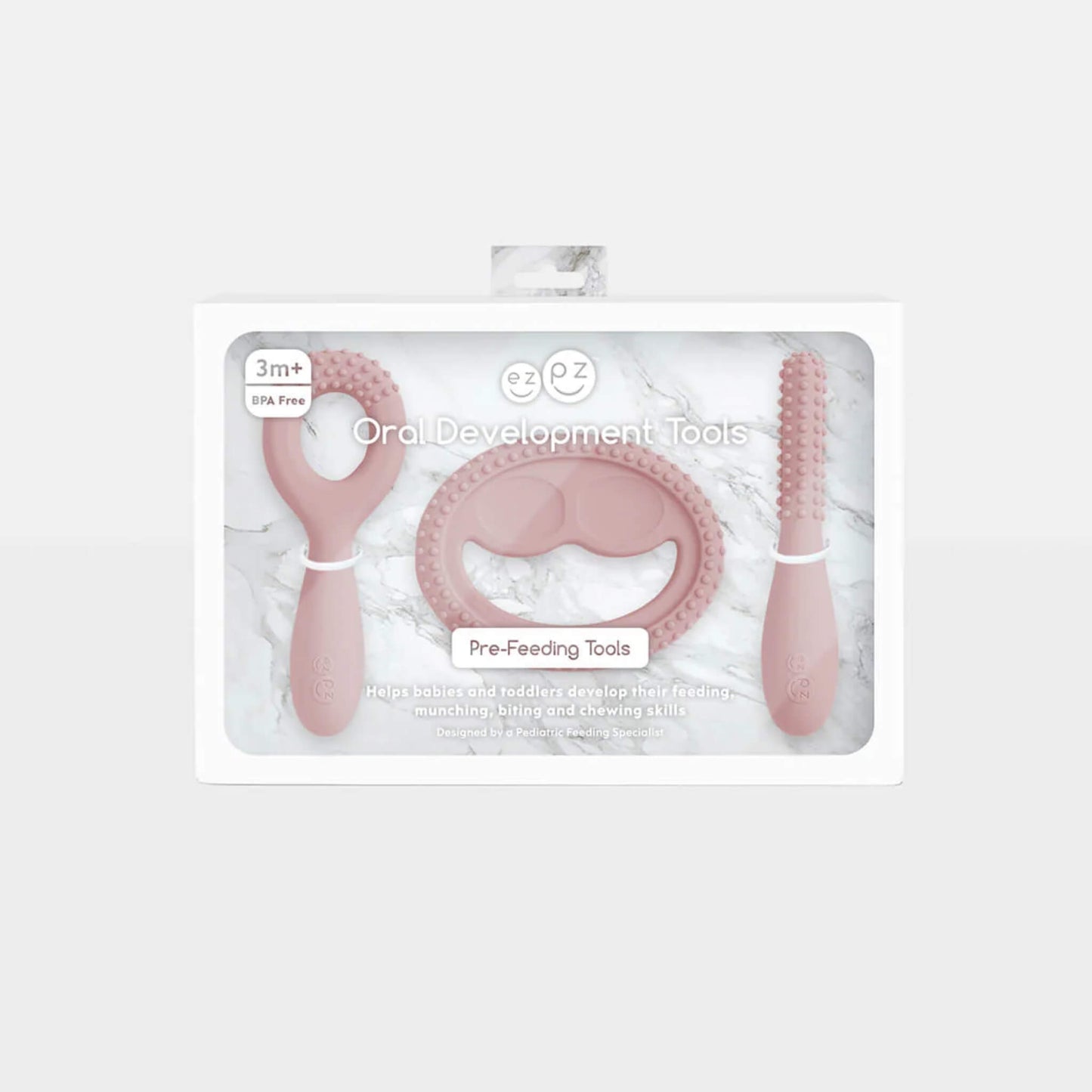 Packaging for a blush pink silicone oral development tool set labelled oral development tools and pre-feeding tools for babies aged 3 months and over.