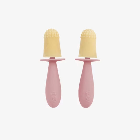 Two small frozen baby popsicles with purée attached to blush silicone handles designed for tiny hands to grip easily.