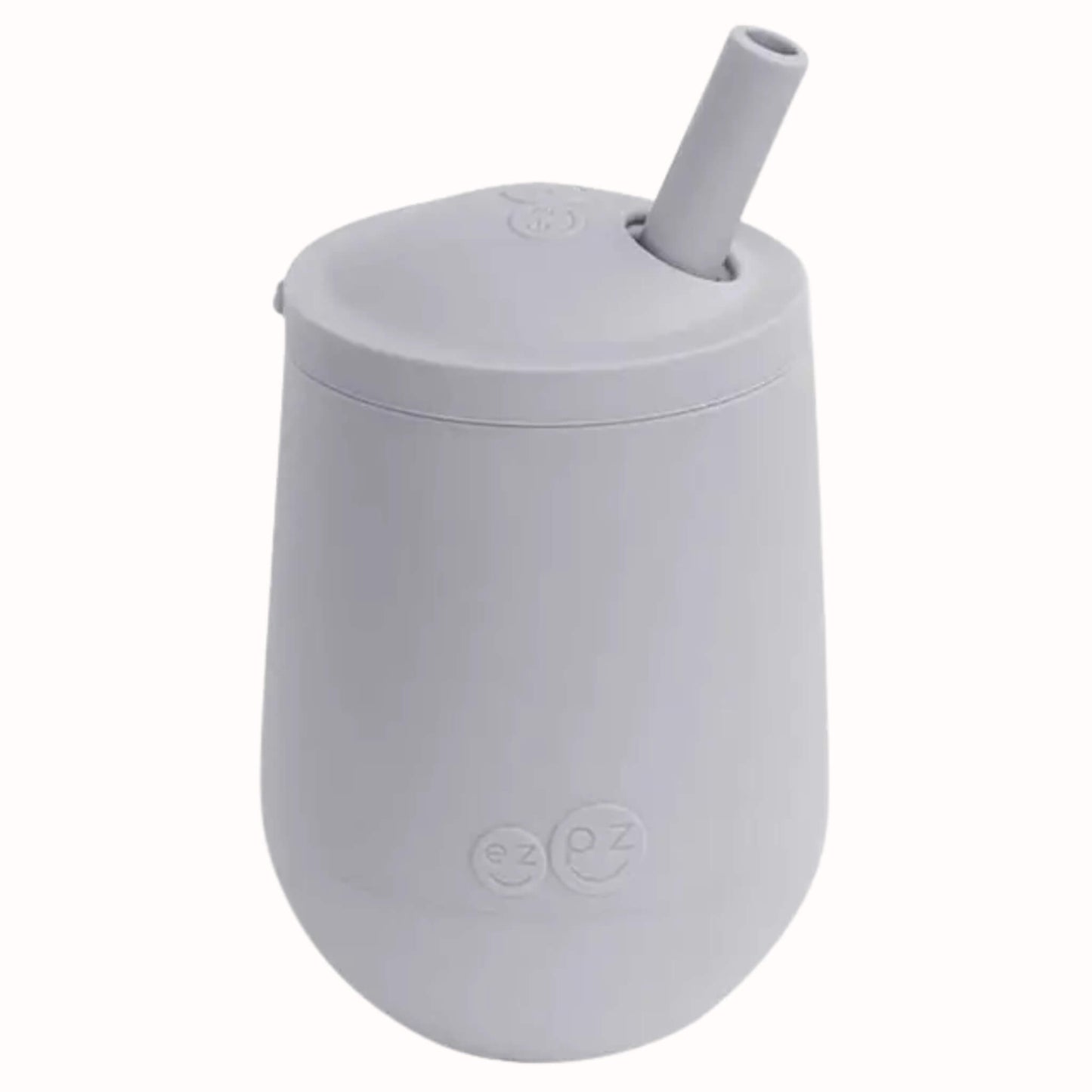 Pewter silicone mini cup with angled straw lid designed to help toddlers learn open cup and straw drinking.