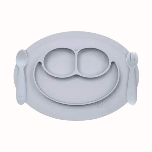 Silicone divided mini mat in pewter with matching spoon and fork placed on either side for toddler self-feeding.
