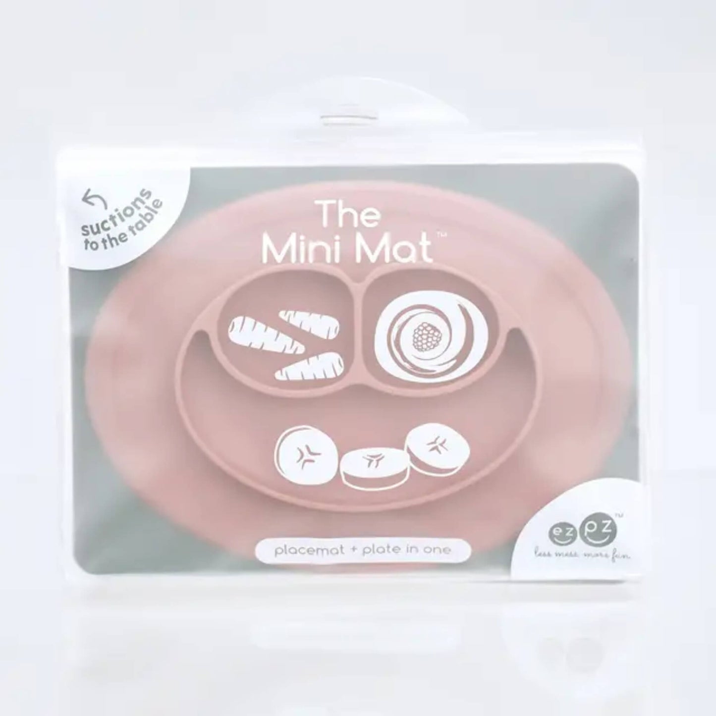 A suction placemat and plate in blush pink silicone with food compartments , placed inside retail packaging.