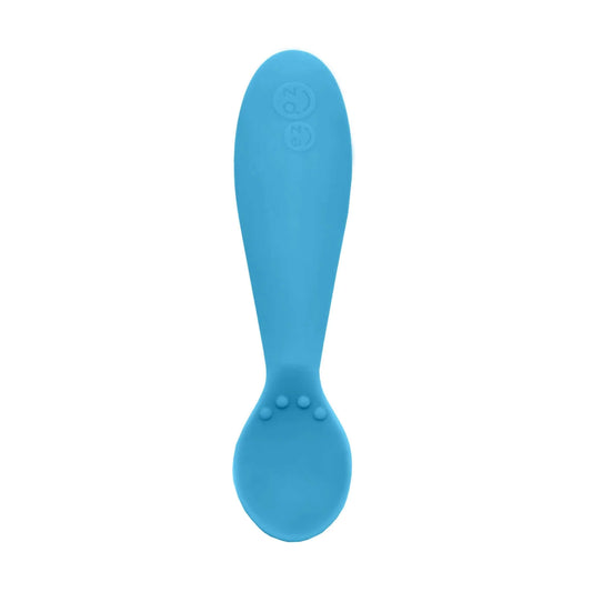 Single blue silicone training spoon with a shallow bowl and textured bumps on the handle, shown close-up.