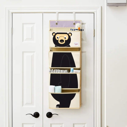 3 Sprouts hanging organiser in use on a white door, neatly holding baby changing supplies in its four spacious pockets.