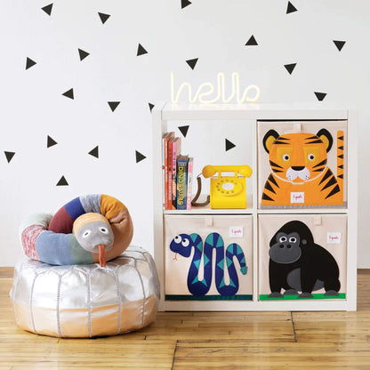 Gorilla box displayed inside a four-cube shelf alongside tiger, snake and telephone props in a modern nursery with triangle wall decals and wooden flooring.