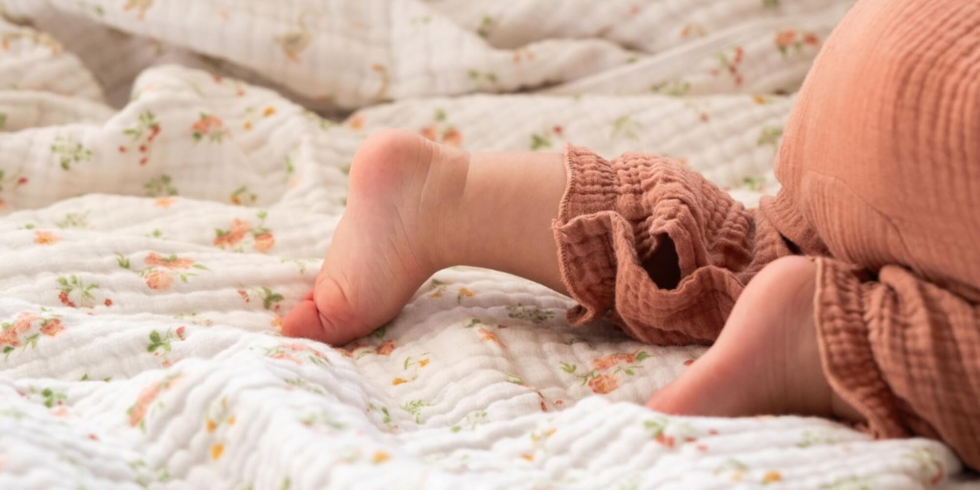 Bebeco homepage banner showing baby’s feet resting on a soft muslin blanket in warm natural light, highlighting gentle textures and cosy comfort.