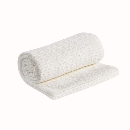 White knitted cellular baby blanket shown rolled with one section unfolded to display the breathable open weave texture.
