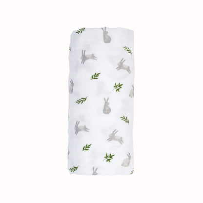 Rolled white muslin swaddle featuring a scattered pattern of soft grey bunnies and small green leaves shown against a plain background.