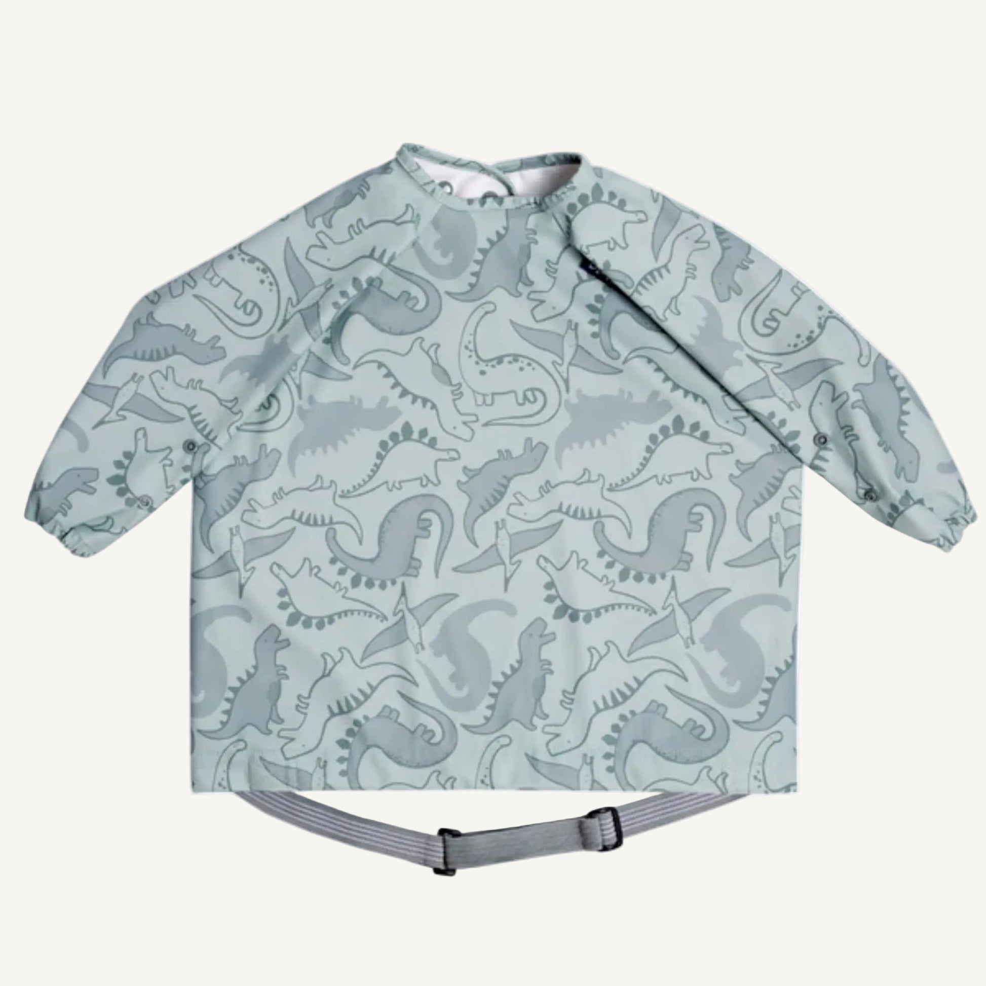 A sage green long sleeve coverall weaning bib with all-over dinosaur print, elasticated cuffs and adjustable waist strap shown flat.