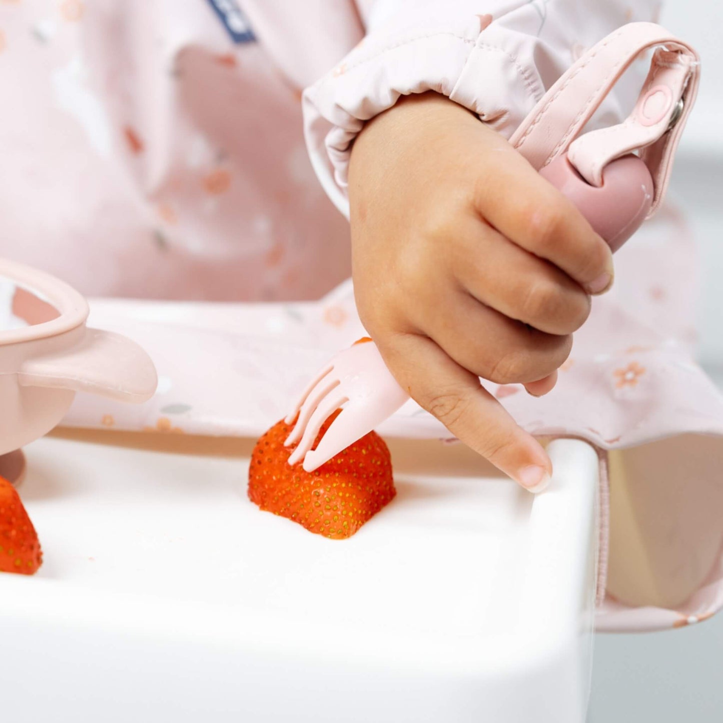 Close-up of small hands gripping the training fork and practising precise hand-eye coordination.