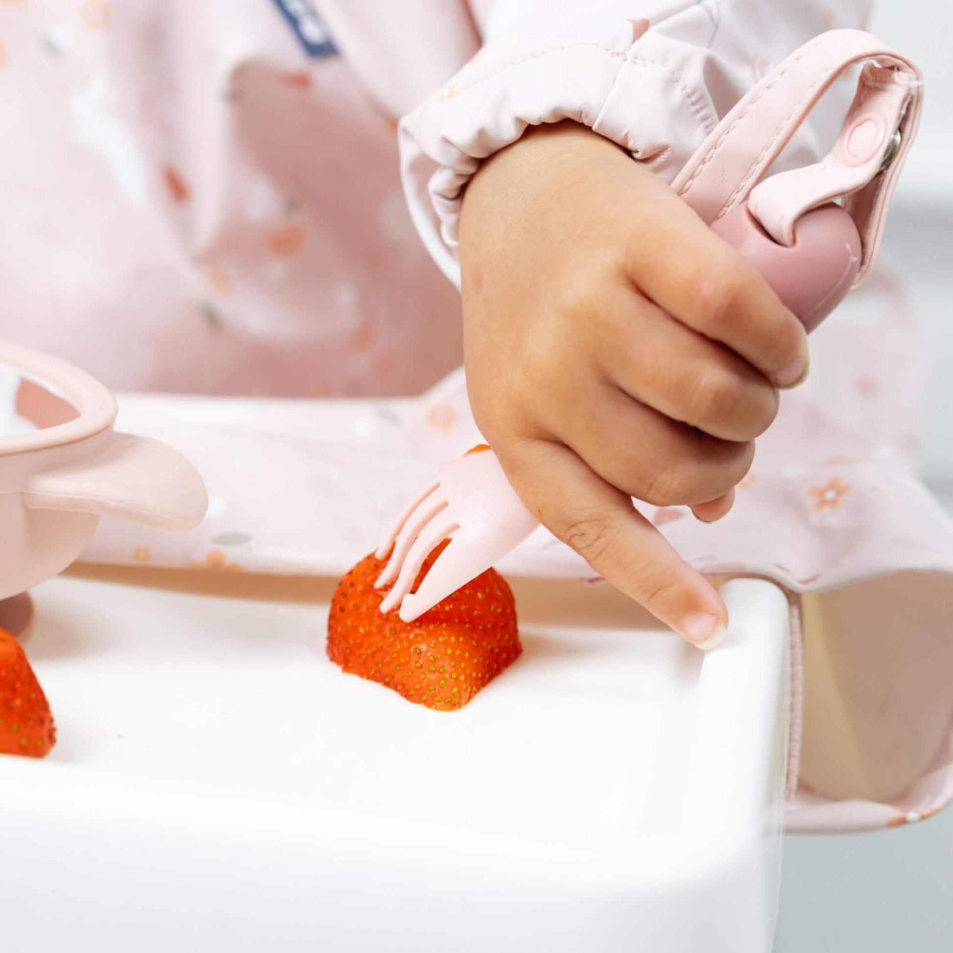 Close-up of small hands gripping the training fork and practising precise hand-eye coordination.