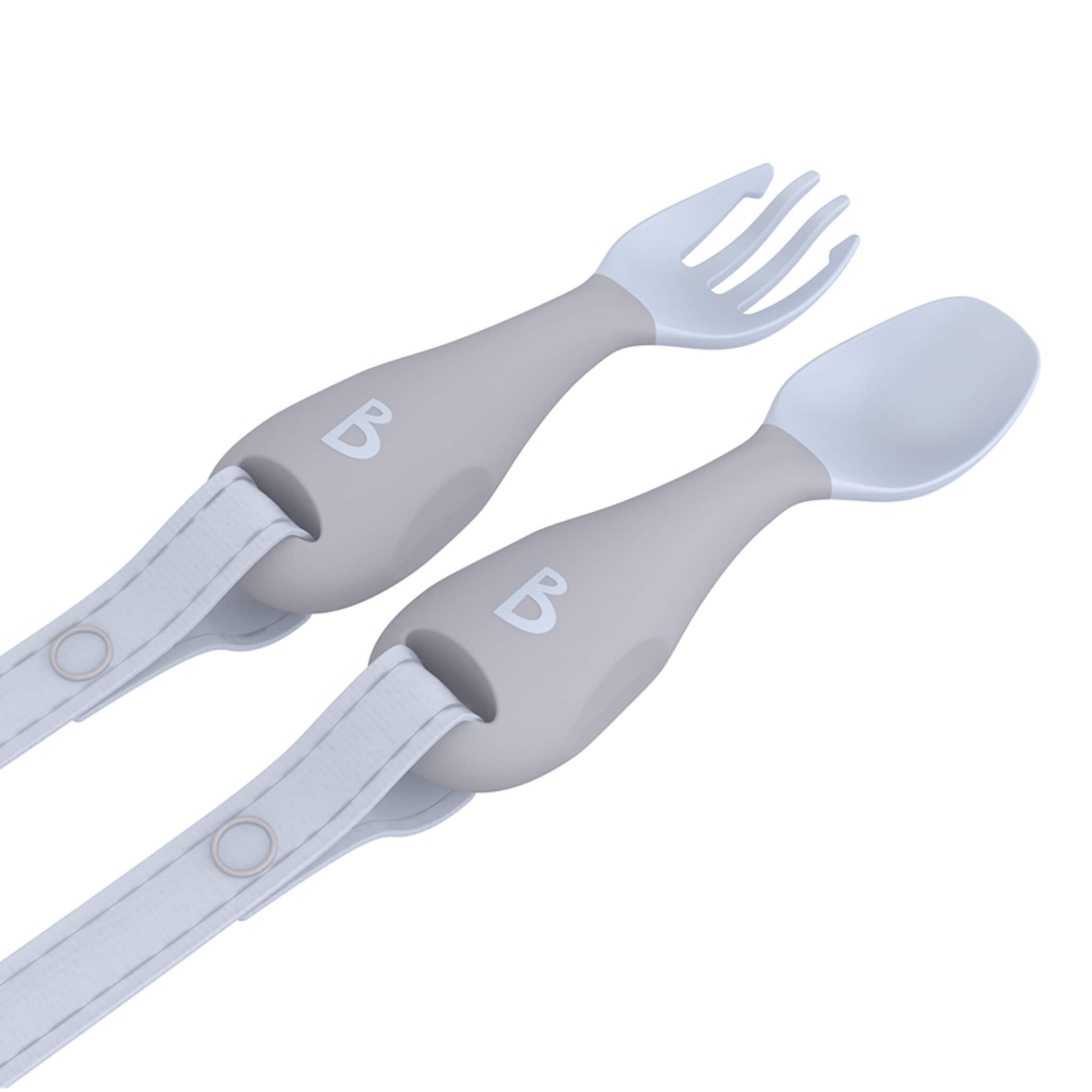 Angled view of the pale grey spoon and fork with popper straps threaded through the handles, designed for early self-feeding.
