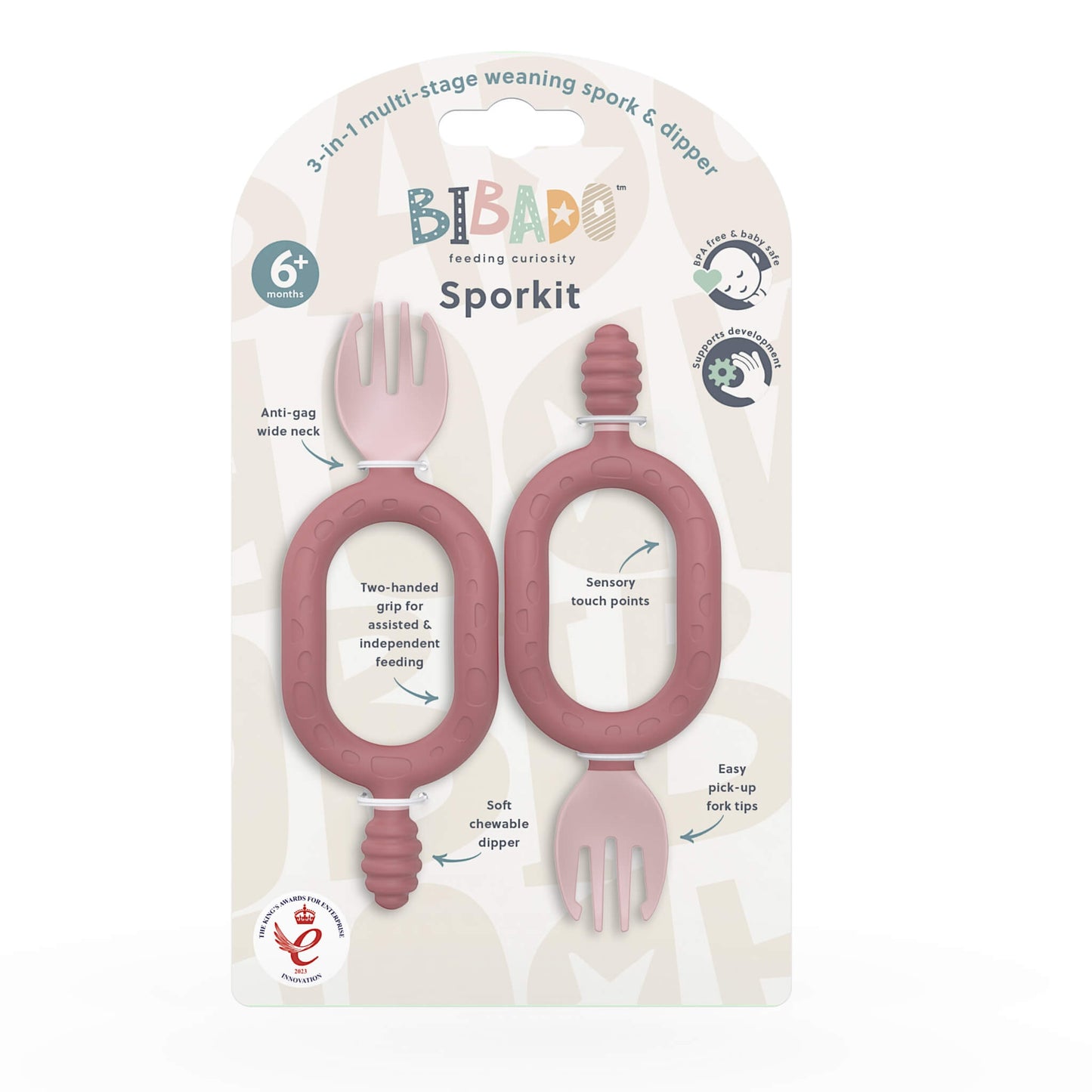 A twin pack of blush pink self-feeding utensils in retail packaging with a scooping spork, textured dipper and dual-handle design.
