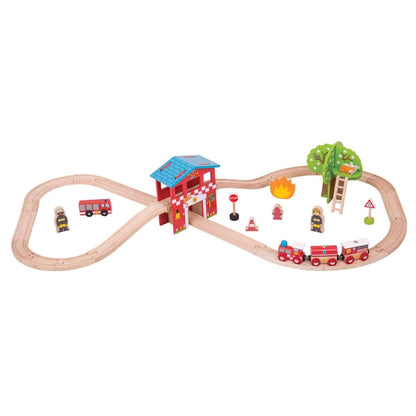 A complete view of the Bigjigs Toys Fire Station Train Set laid out in a figure-of-eight track, featuring red fire-themed trains, a fire station building, ladder, tree, fire truck, fire crew, and accessories.