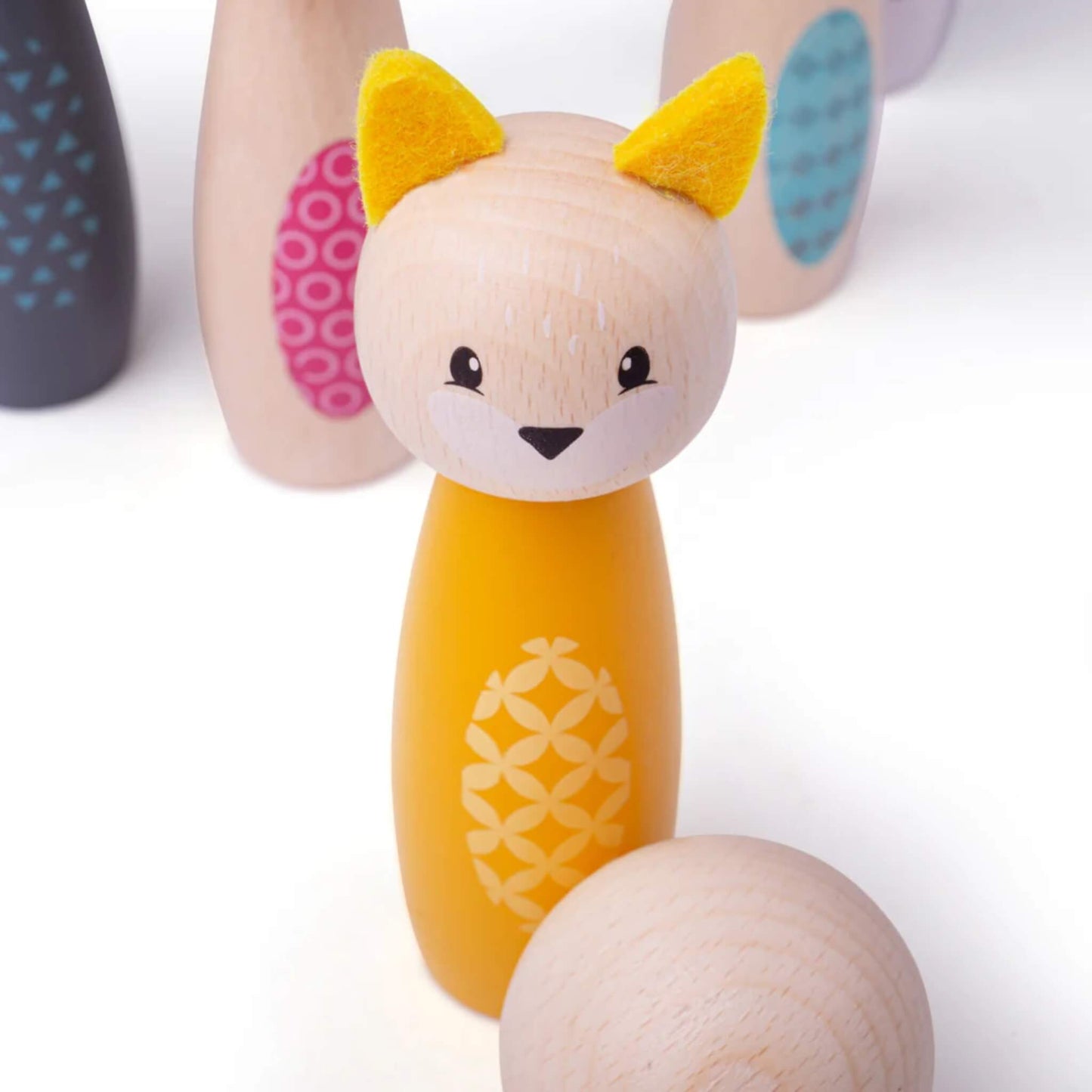 Close-up of the fox skittle with the wooden ball in the foreground, showing painted details and felt ears.