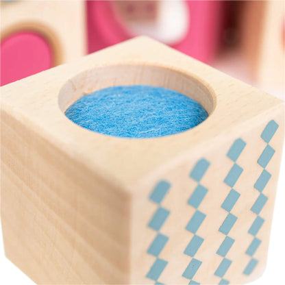 Detailed close-up of the blue felt texture on one of the sensory blocks, set inside a natural wooden cube with a soft blue diamond pattern.