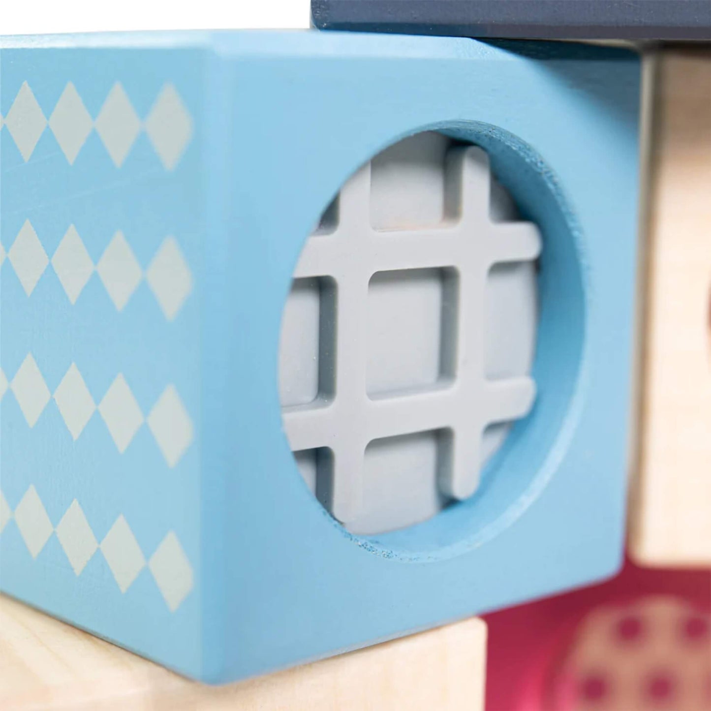 Macro shot of the soft rubber grid insert on the pale blue sensory block, designed for tactile exploration.