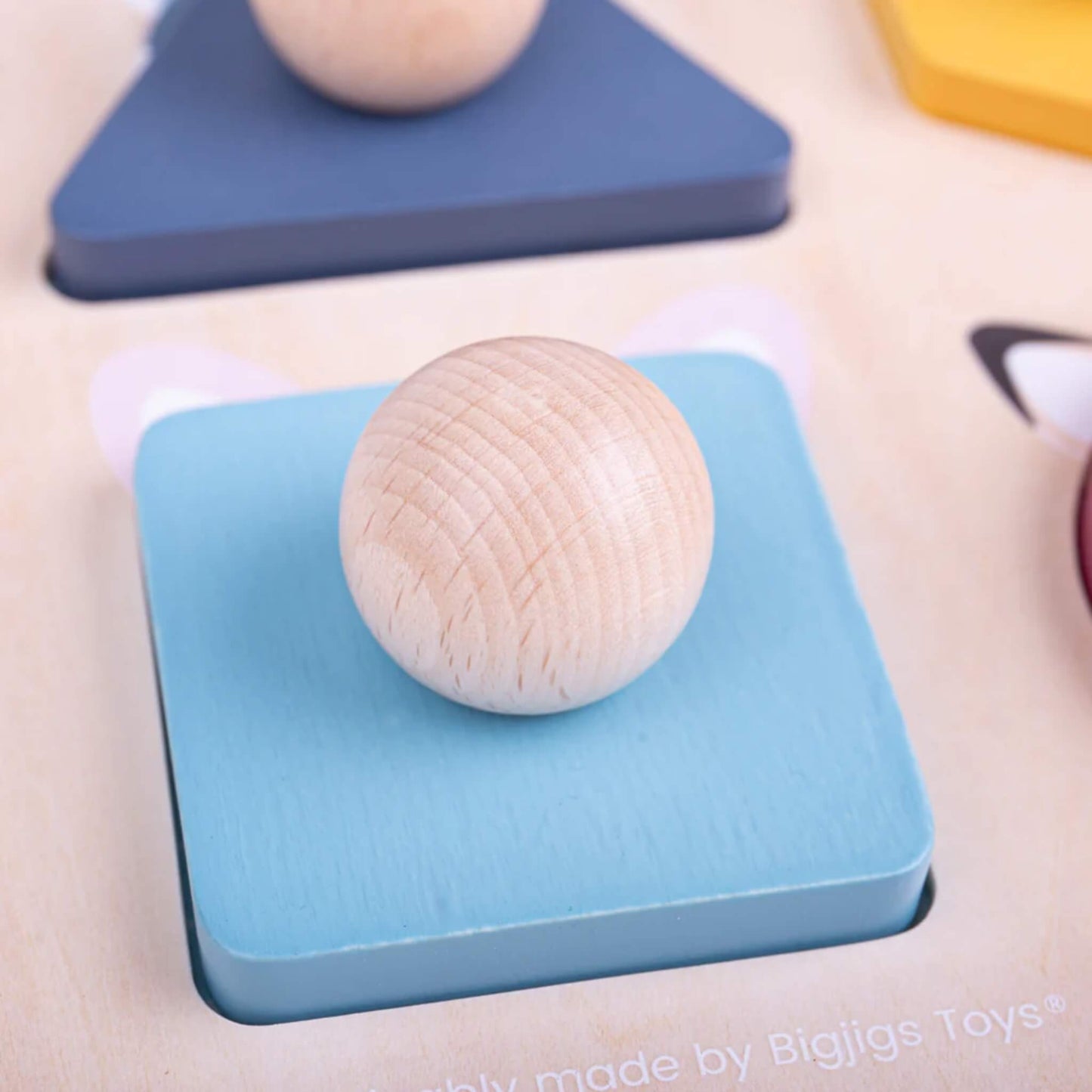 Close-up of the blue square puzzle piece with wooden knob from the Bigjigs Toys Woodland Shape Puzzle.