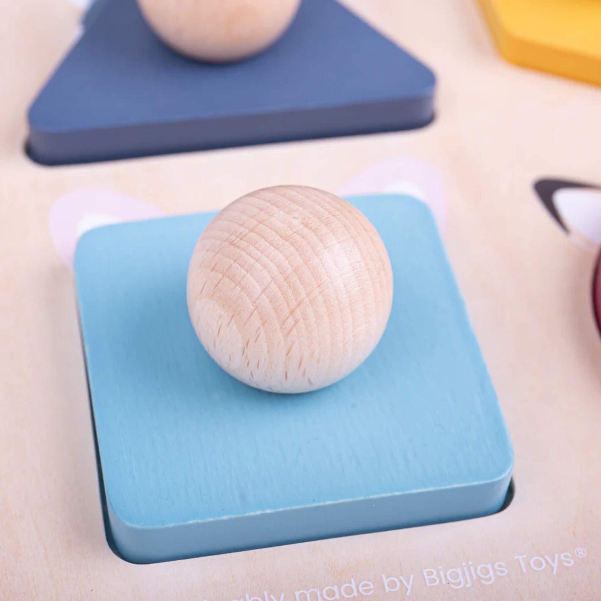 Close-up of the blue square puzzle piece with wooden knob from the Bigjigs Toys Woodland Shape Puzzle.
