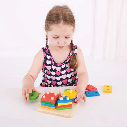 Child carefully placing a round wooden piece onto the pegged baseboard, encouraging hand-eye coordination and problem-solving.