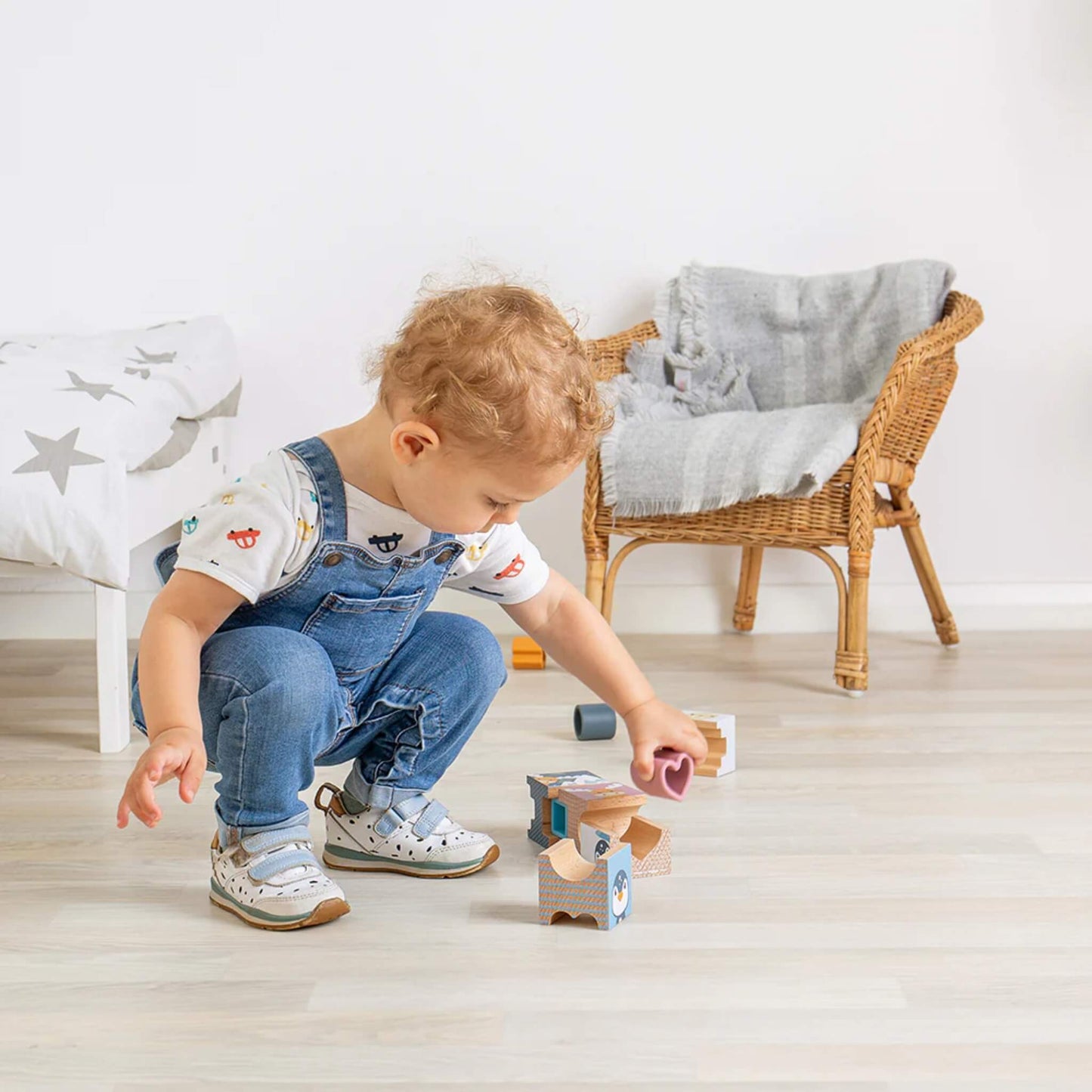 Toddler experimenting with Arctic tower blocks, discovering how pieces fit together through play.