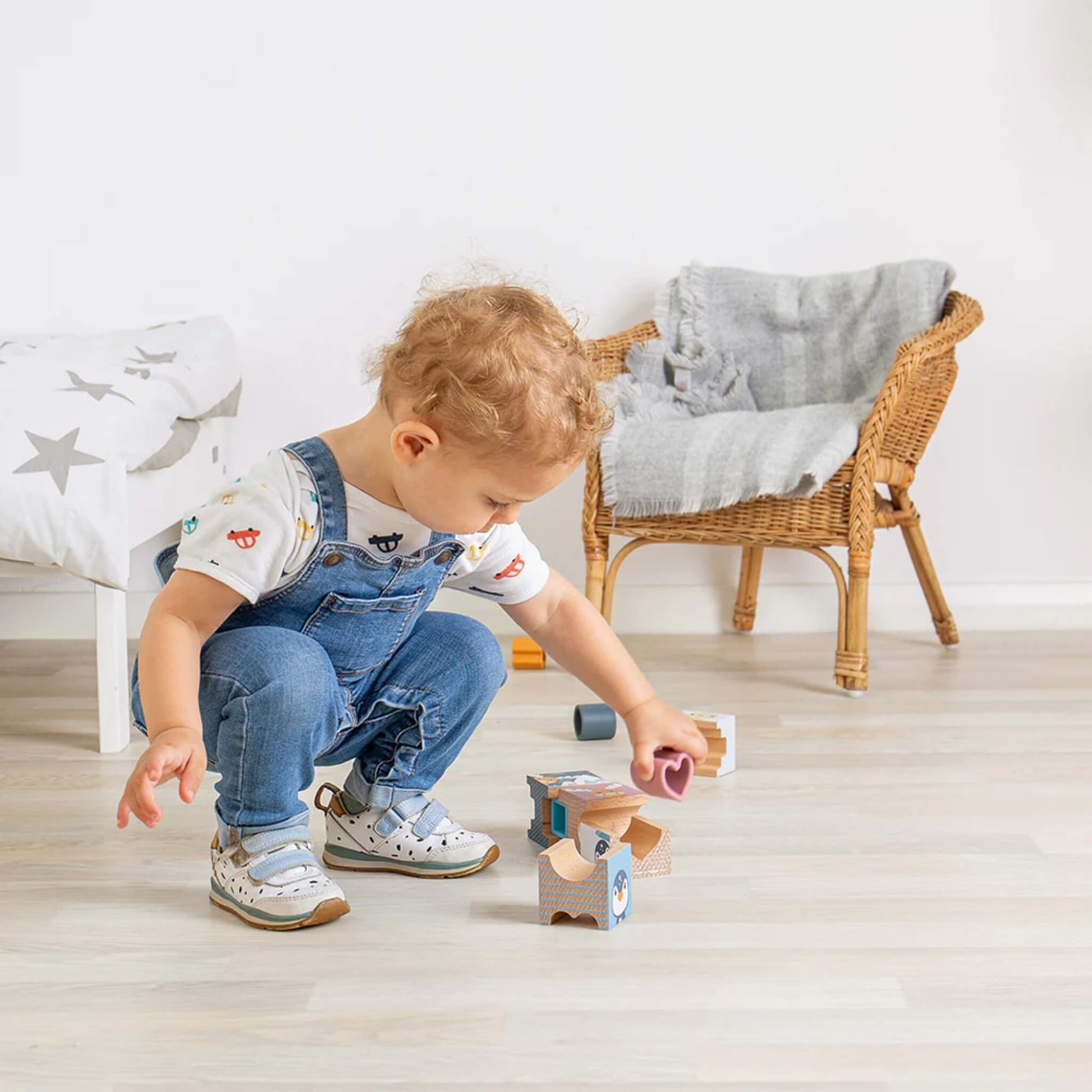Toddler experimenting with Arctic tower blocks, discovering how pieces fit together through play.