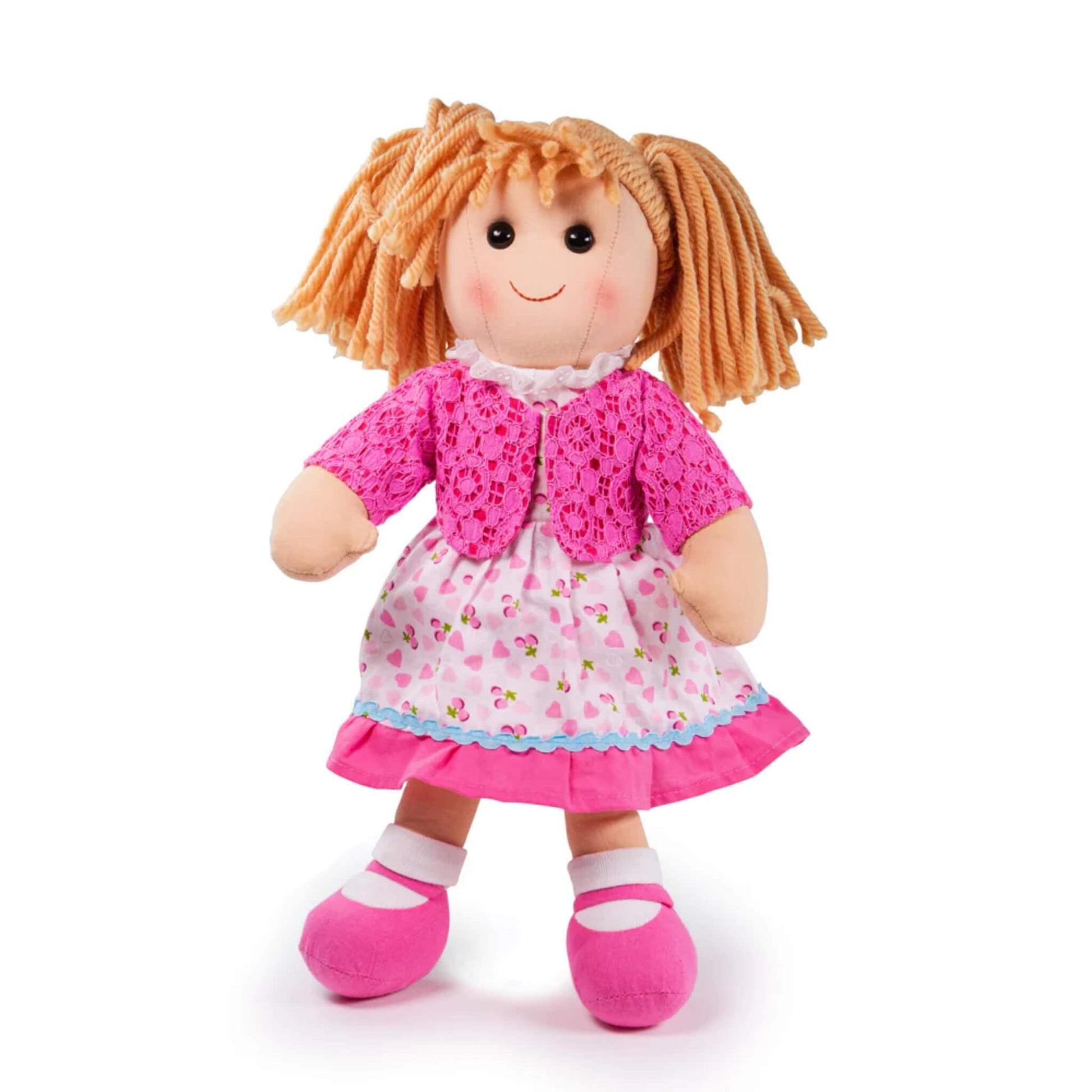 Bigjigs Toys Becky Doll shown standing in her pink heart-print dress and lacy cardigan, with blonde yarn hair in bunches and matching pink shoes.