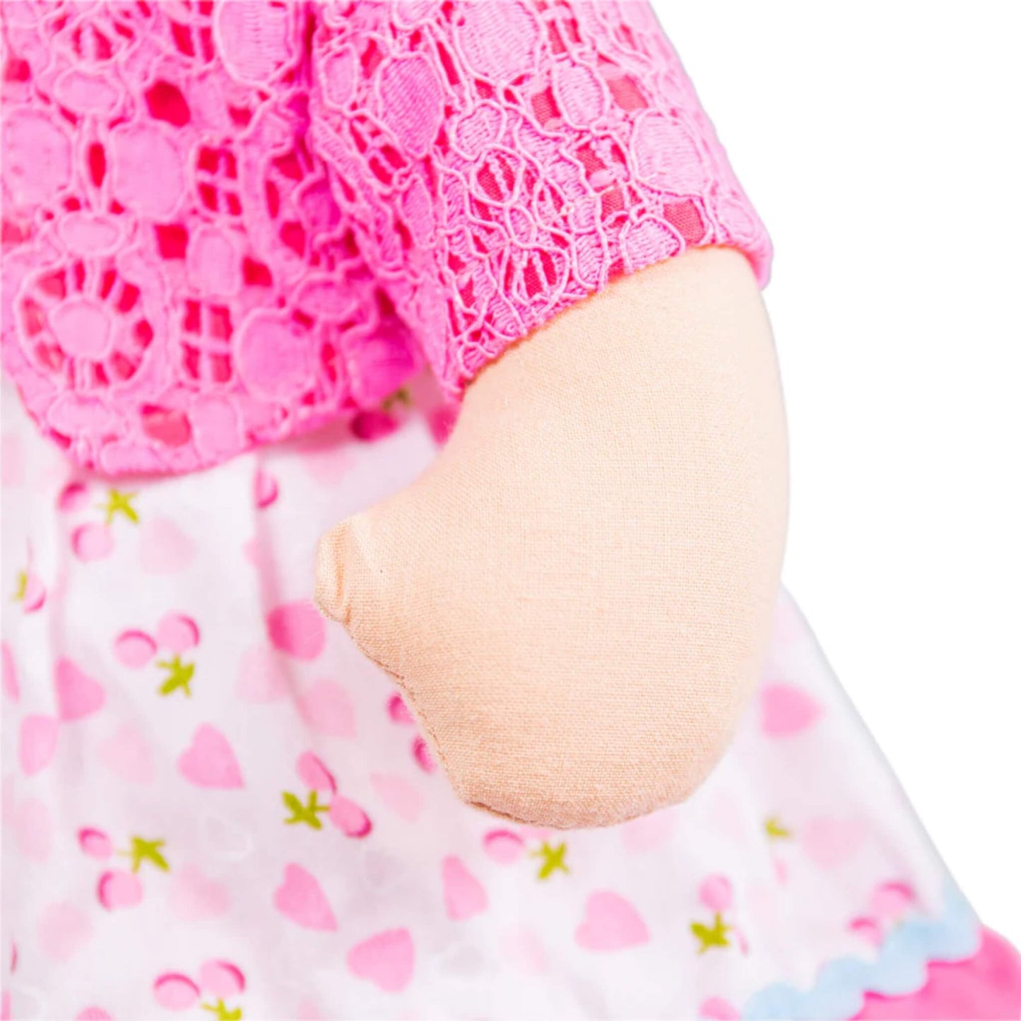 Close-up of the doll’s plush hand and floral-print sleeve under her lacy cardigan.