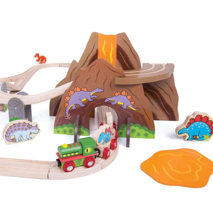 Side view of the dinosaur train passing through the volcano tunnel, surrounded by lava pieces and dinosaur figures on wooden tracks.