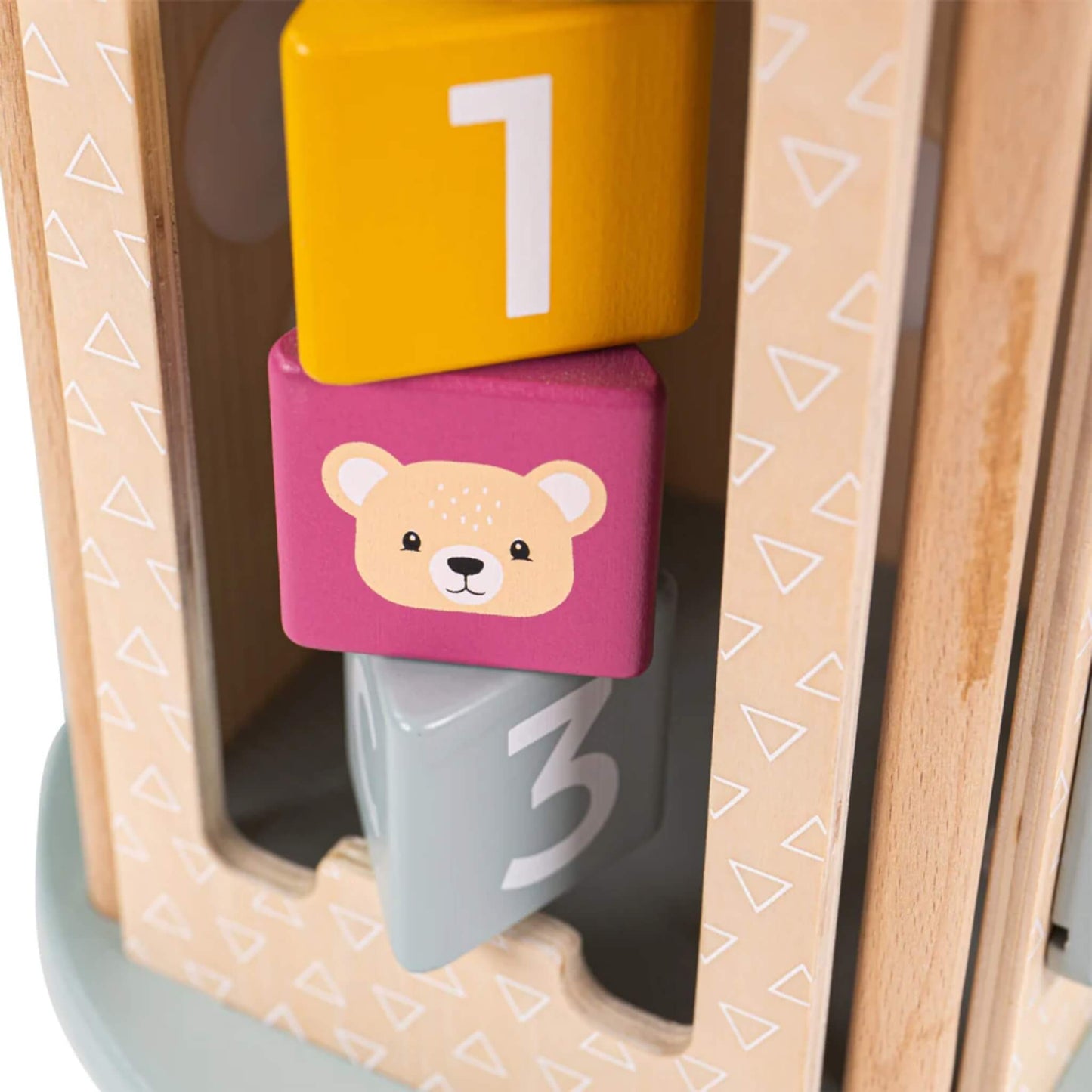 Close-up of numbered and illustrated wooden blocks inside the spinning column, including a bear face and number blocks.