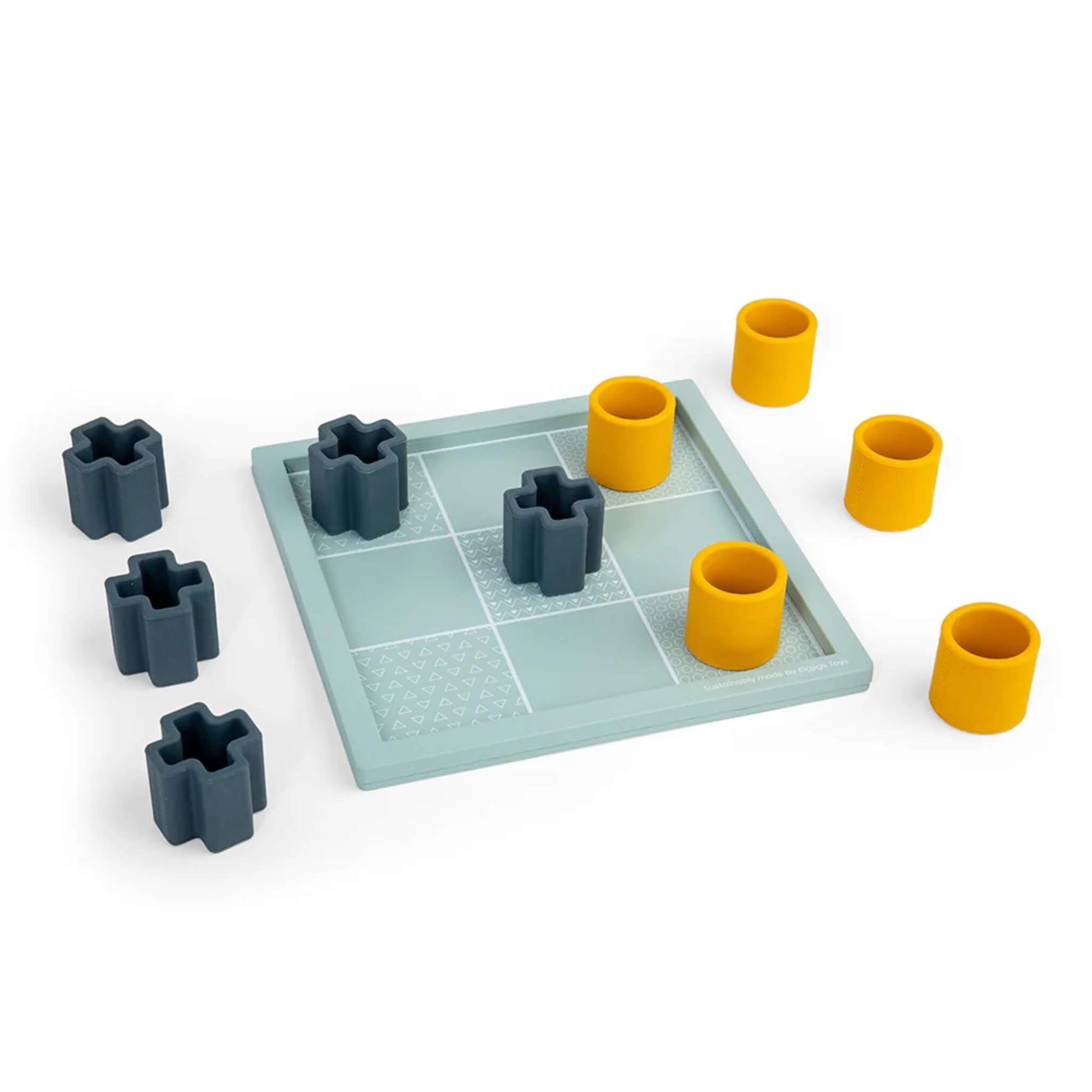 All nine playing pieces spread out on and around the Tic Tac Toe board, with the board’s etched textures clearly visible.