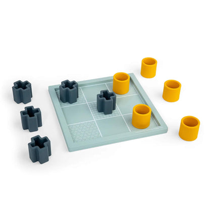 All nine playing pieces spread out on and around the Tic Tac Toe board, with the board’s etched textures clearly visible.