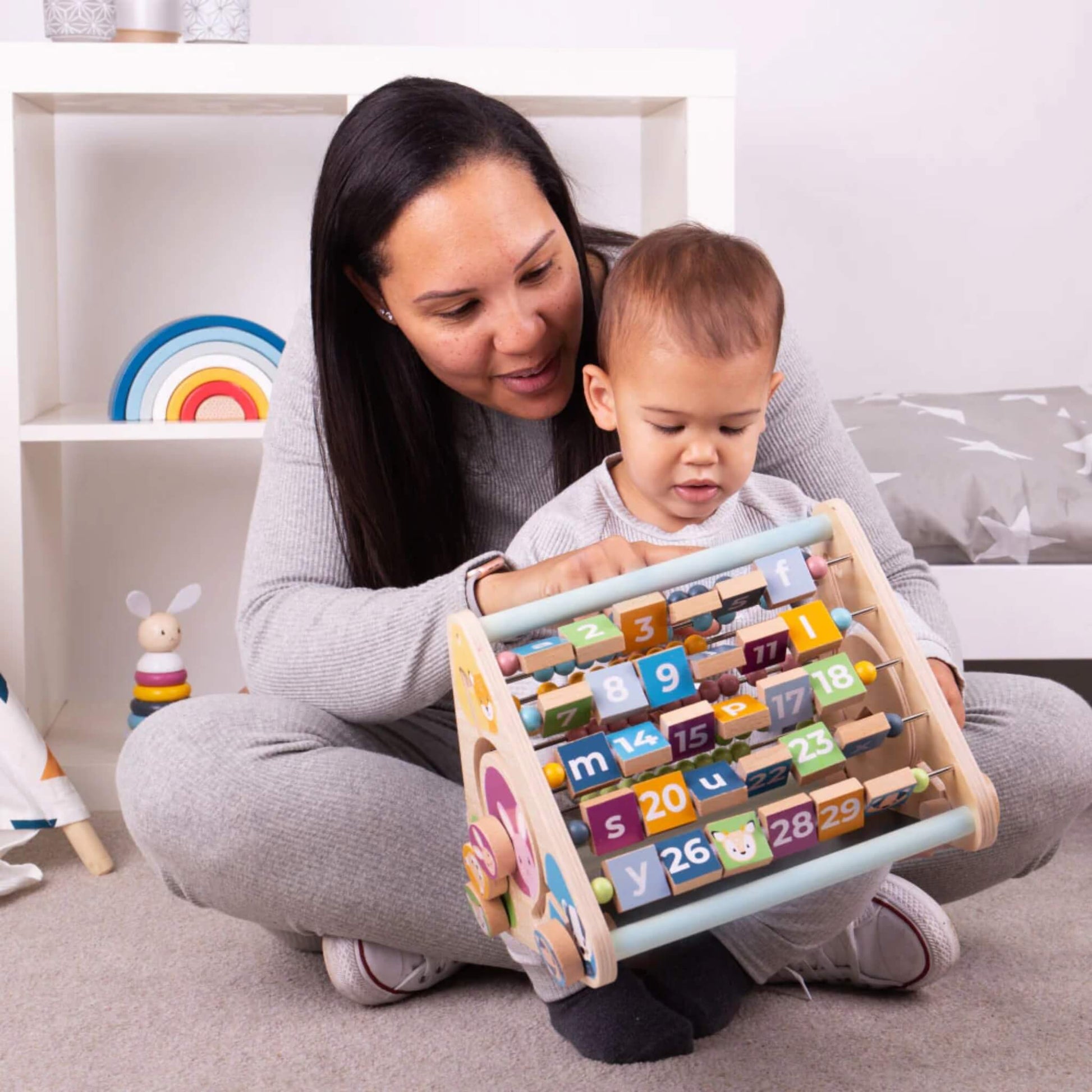 Mother and toddler engaging with the Bigjigs Toys activity centre, encouraging shared learning and interaction.