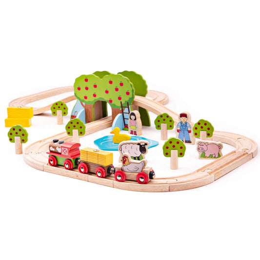 Wooden farm train set featuring a red engine, carriages with hay and animals, apple trees, a pond with duck, and farmers set up on wooden track.