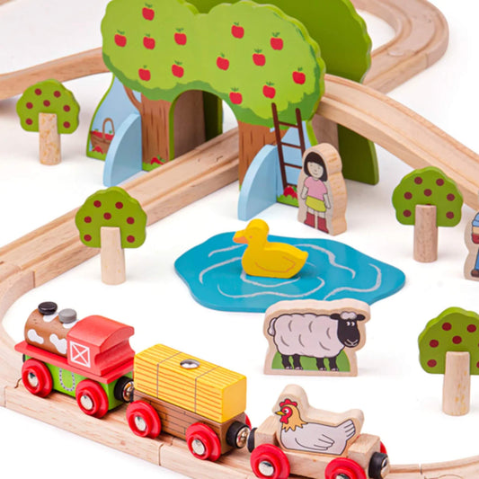 Yellow duck floating on a blue pond, surrounded by apple trees, a girl figure, and the train engine pulling sheep and chicken carriages.