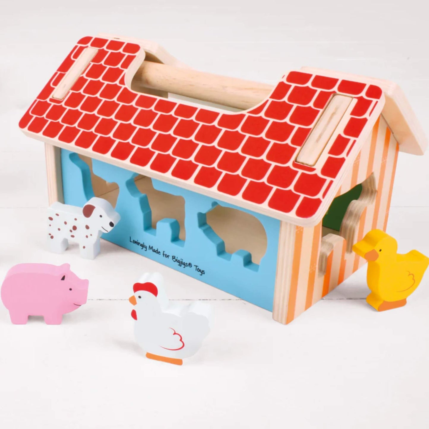 Farmhouse shape sorter with wooden animal pieces placed around it, highlighting the bright, sturdy construction and cut-out animal slots.