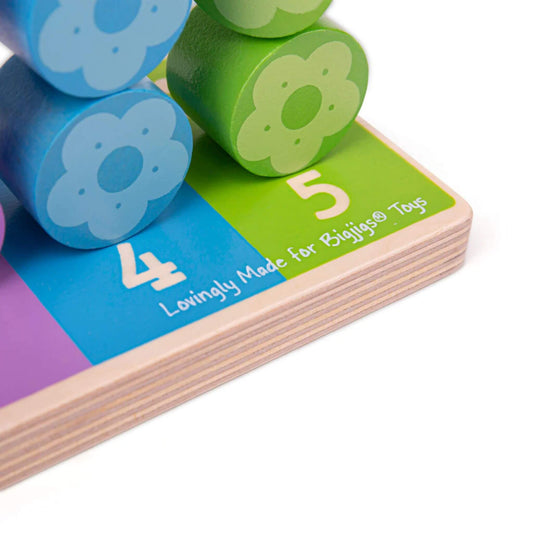 Close-up of brightly coloured flower pieces stacked on a wooden baseboard, showing numbers 4 and 5.