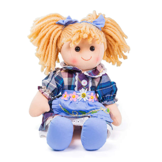 Close-up seated view – Katie Doll seated upright, showing her detailed plaid dress, floral belt, and embroidered apron, with rosy cheeks and a gentle smile.