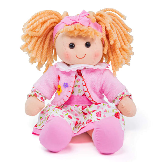 Kelly doll seated, showing her smile, pigtails, and outfit with pink love heart pattern and applique cardigan.
